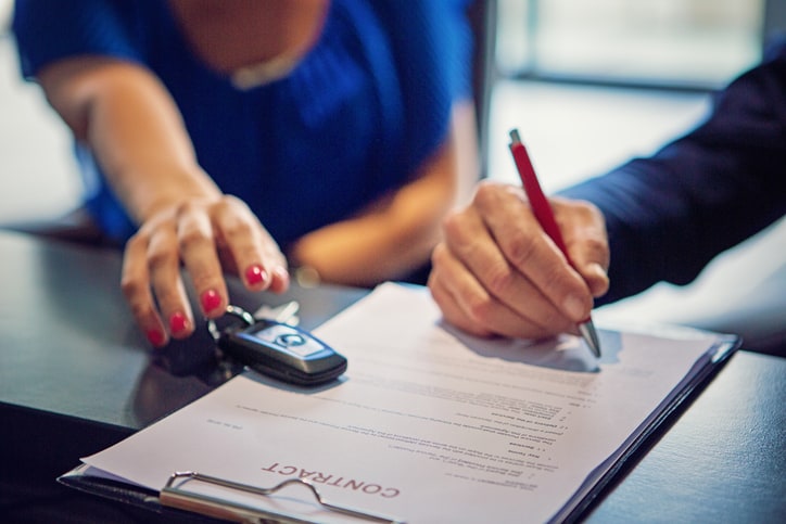 People signing contract for new car